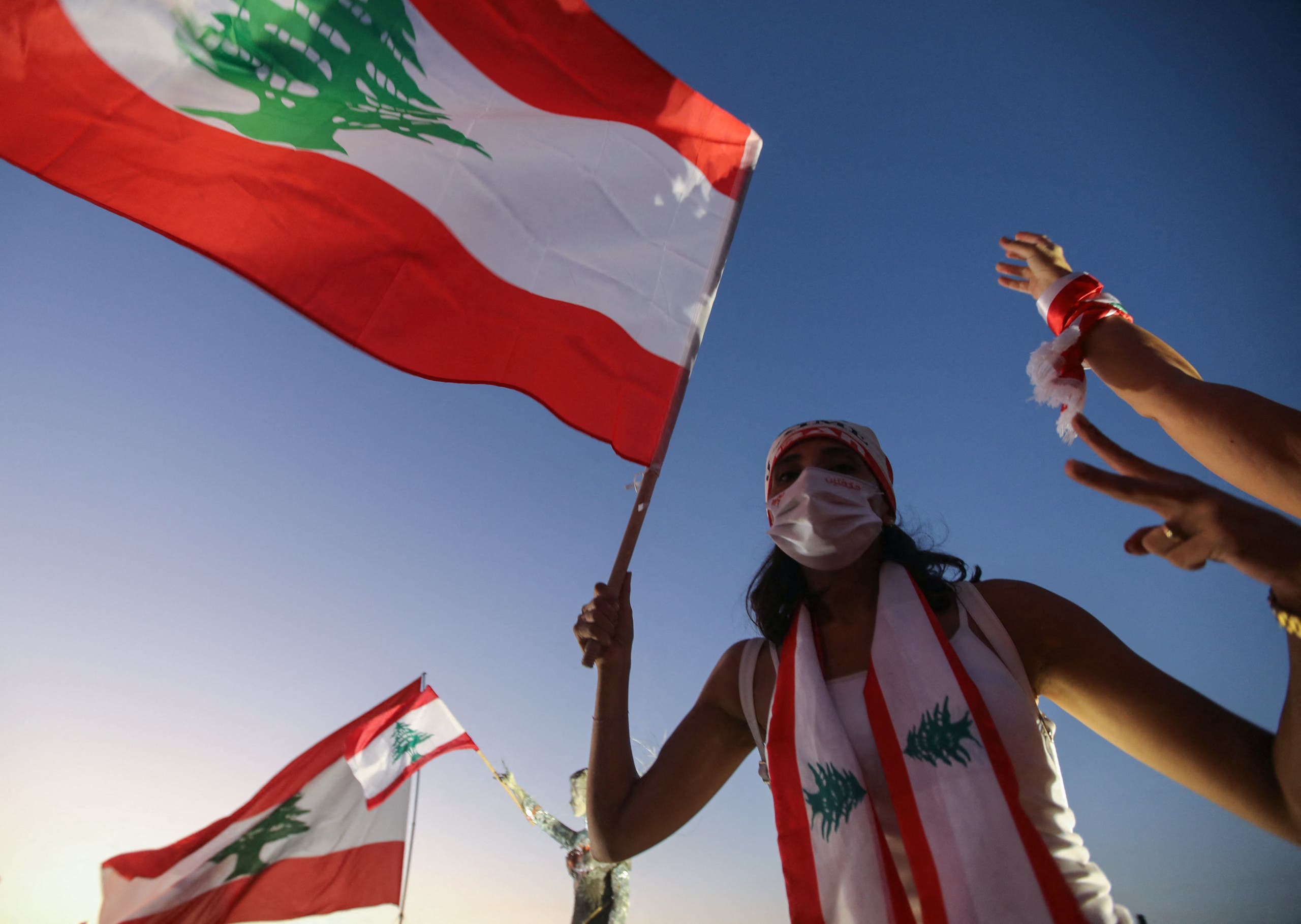 A Lebanese protester lifts a national flag during a demonstration. (Stock photo)