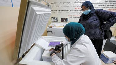 A medical worker unpacks a box of Pfizer-BioNTech COVID-19 coronavirus vaccine vials from a refrigerator at a vaccination centre in Iraq's capital Baghdad on July 19, 2021. (Ahmad Al-Rubaye/AFP)