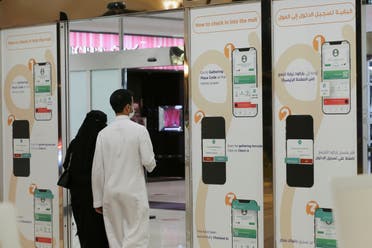A Saudi man and his wife enter Granada Mall, after displaying the Tawakolna app, launched by the Saudi authorities to help track people infected with the coronavirus disease (COVID-19), in Riyadh, Saudi Arabia March 3, 2021. (Reuters)