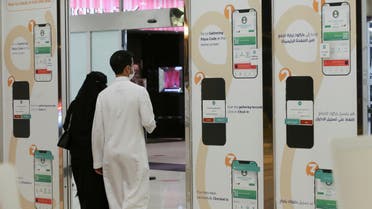 A Saudi man and his wife enter Granada Mall, after displaying the Tawakkalna app, launched by the Saudi authorities to help track people infected with the coronavirus disease (COVID-19), in Riyadh, Saudi Arabia March 3, 2021. (Reuters)