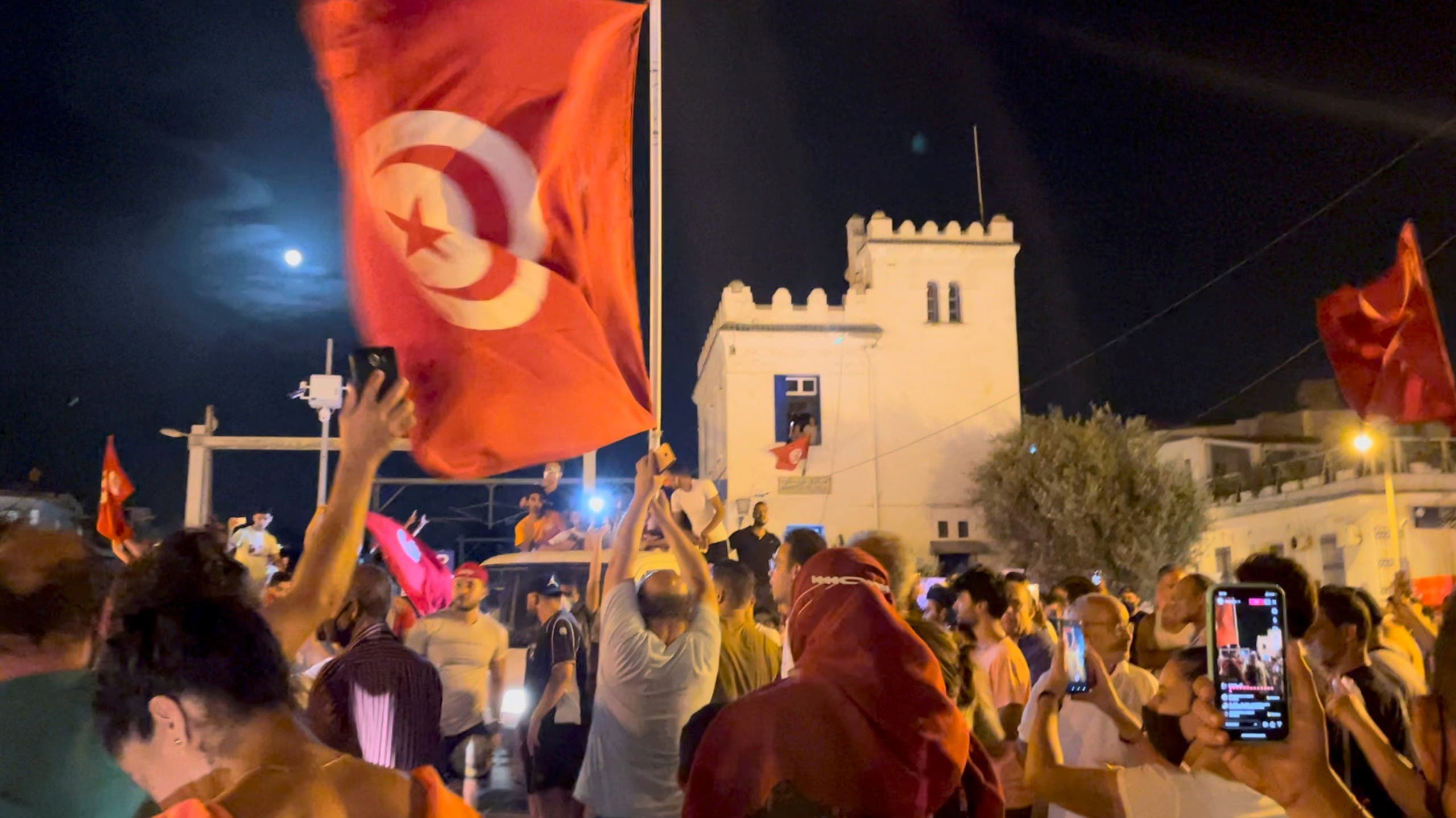 Supporters of the Tunisian president celebrate the dismissal of the government on Sunday night with hymns and fireworks