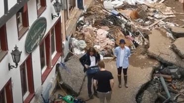 German reporter smears mud on clothes, pretends to clear up flood-ravaged town2. (Screengrab via YouTube)