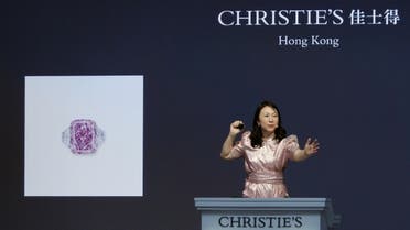 An auctioneer holds the gavel during Christie's auction of Sakura Diamond, a 15.81 carat purple pink diamond ring, in Hong Kong, China, on May 23, 2021. (Reuters)