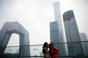 Women pose for pictures at a shopping mall near the CCTV headquarters and China Zun skyscraper in Beijing's central business district (CBD), China, July 16, 2020. (Reuters)