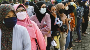 People wearing protective face masks queue to receive a dose of China's Sinovac Biotech vaccine for coronavirus disease (COVID-19) during a mass vaccination program at a school building in Jakarta, Indonesia, July 26, 2021. (Reuters)