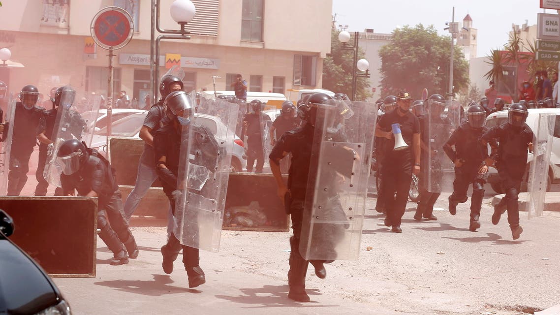 Police officers run towards demonstrators during an anti-government protest in Tunis, Tunisia, July 25, 2021. (Reuters)