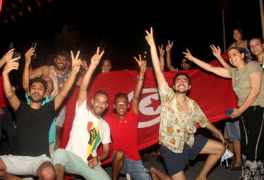 Demonstrators celebrate with a Tunisian national flag during a rally after the president suspended the legislature and fired the prime minister in Tunis, Tunisia, Sunday, July 25, 2021. (AP)