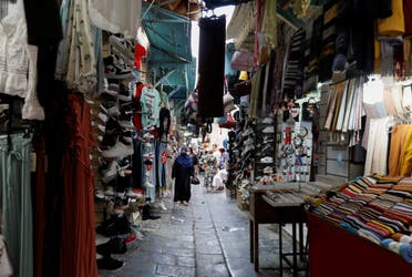 People walk past shops in the Medina, in the old city of Tunis, Tunisia, July 27, 2021. (Reuters)
