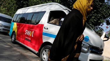 A woman walks past a vehicle with a logo of the Egyptian transport technology start-up Swvl, parked along a road in Islamabad, Pakistan, November 11, 2019. (Reuters)