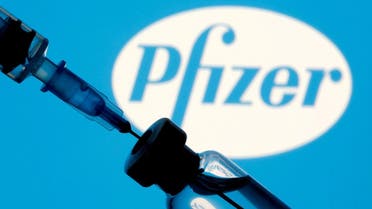 A vial and syringe are seen in front of a displayed Pfizer logo in this illustration. (Reuters)