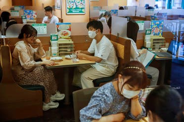 People sit in a restaurant using plexiglass separators to protect customers from coronavirus in the Shibuya area of Tokyo, Japan, July 29, 2021. (Reuters)
