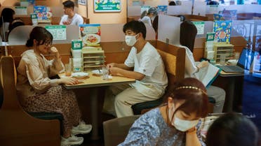 People sit in a restaurant using plexiglass separators to protect customers from coronavirus (COVID-19) disease in the Shibuya area of Tokyo, Japan, July 29, 2021.  (Reuters)