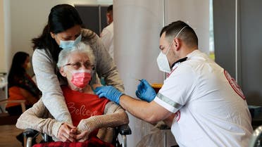 An elderly woman receives a booster shot of her vaccination against the coronavirus disease (COVID-19) at an assisted living facility, in Netanya, Israel January 19, 2021.  (Reuters)