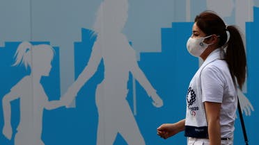  woman wearing a protective mask, amid the coronavirus disease (COVID-19) outbreak, walks past a fence outside the National Stadium, the main venue of the Tokyo 2020 Olympic Games in Tokyo, Japan, July 28, 2021. (File photo: Reuters)