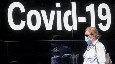 A woman wearing a mask passes by a coronavirus disease mobile testing van, as cases of the infectious Delta variant of COVID-19 continue to rise, in Washington Square Park in New York City, U.S., July 22, 2021. (Reuters)