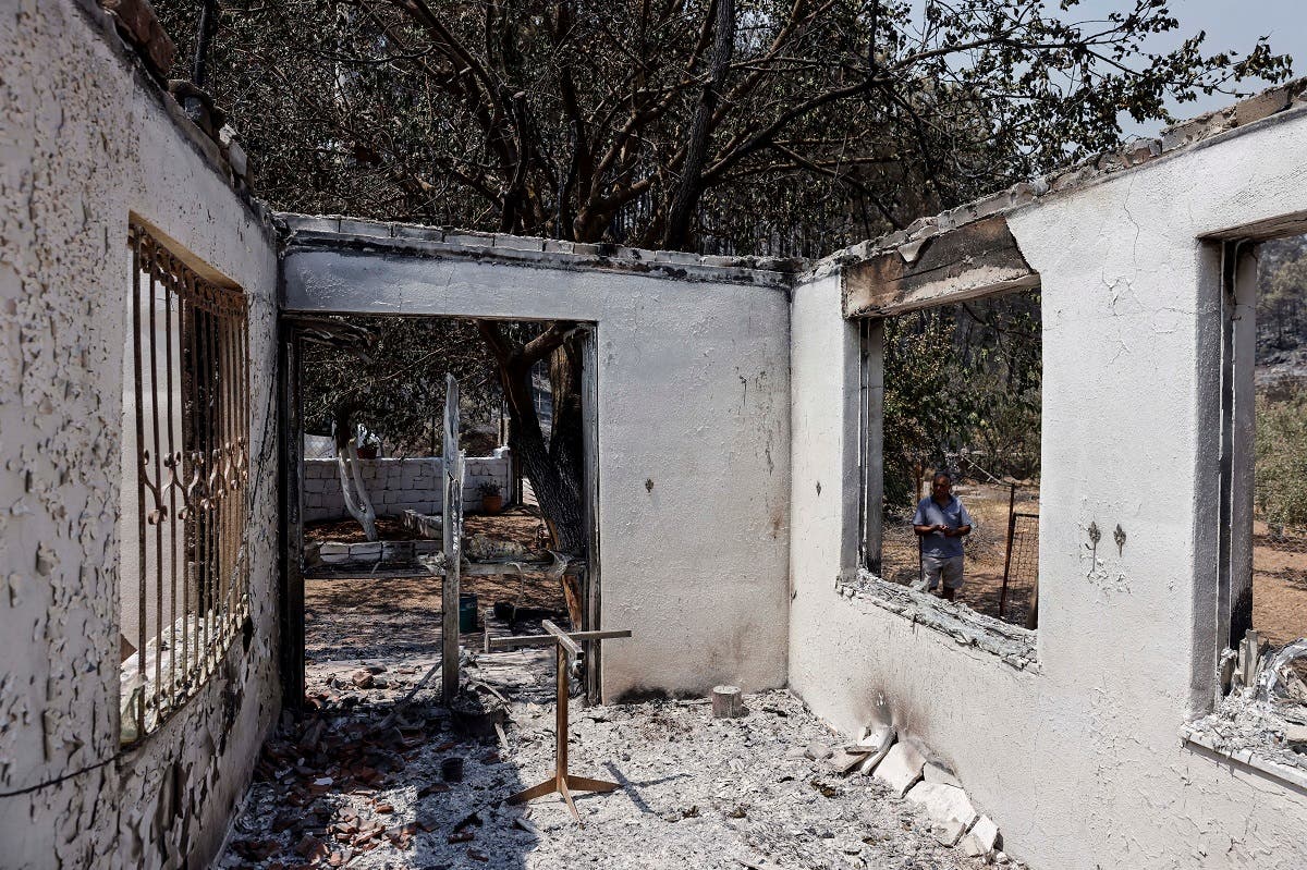 A man stands in front of his burnt house during a wildfire near Marmaris, Turkey, July 31, 2021. (Reuters/Umit Bektas)