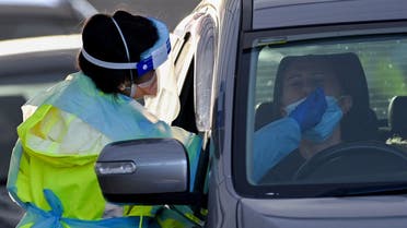 A health worker dressed in protective gear conducts COVID-19 testing at the St. Vincents Hospital drive-through testing clinic at Bondi in Sydney on July 6, 2021, as the city remains in lockdown for a second week to contain an outbreak of the highly contagious Delta Covid-19 variant.