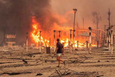  A man walks in front of a fire at Le Capannine beach in Catania, Sicily, Italy, July 30, 2021, in this photo obtained from social media on July 31, 2021.( Roberto Viglianisi/via Reuters)