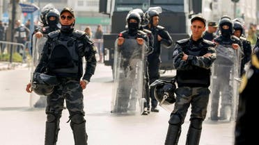 Members of security forces keep watch as supporters of Tunisia's biggest political party, the moderate Islamist Ennahda, march during a rally in opposition to President Kais Saied, in Tunis, Tunisia February 27, 2021. (Reuters)