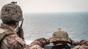 Marines onboard the amphibious transport dock ship USS John P. Murtha (LPD 26) watch nearby Iranian fast inland attack craft, as it transits the Strait of Hormuz, off Oman, in this undated handout picture released by U.S. Navy on August 12, 2019. (File photo: Reuters)