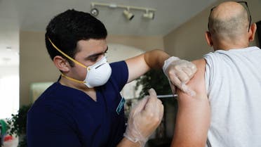 Ledsiel Garcia, a pharmacy technician with DeliveRxd Pharmacy based in Tampa, administers the Pfizer-BioNTech coronavirus disease (COVID-19) vaccine to Mike Payne, a federal employee, at his home in St. Petersburg, Florida, U.S., July 30, 2021. (Reuters)