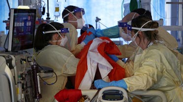 Firefighters Dan Joslin (2L) and Tom Ventress (2R) work alongside critical care nurses to prone a Covid-19 patient in the Intensive Care Unit (ICU) at Queen Alexandra Hospital in Portsmouth, southern England on March 23, 2021. (File photo: AFP)