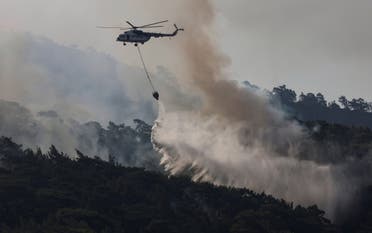A firefighting helicopter drops water to a wildfire near Marmaris, Turkey, August 2, 2021. (Reuters)