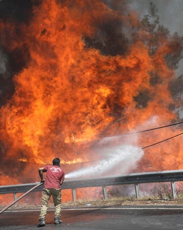 A firefighter tries to extinguish a wildfire near Marmaris, Turkey, August 1, 2021. (Reuters)