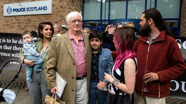 Britain’s former ambassador to Uzbekistan, Craig Murray (3rd L) waits with members of his family outside St Leonard’s Police Station in Edinburgh on August 1, 2021. (Andy Buchanan/AFP)