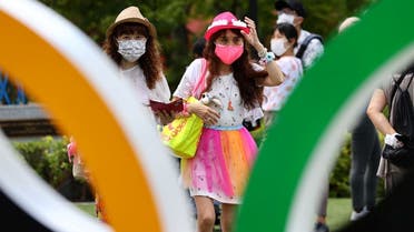 People wearing protective face masks, amid the coronavirus disease (COVID-19) outbreak, visit an Olympic Ring outside the National Stadium, the main venue of the Tokyo 2020 Olympic Games, in Tokyo, Japan, on August 3, 2021. (Reuters)