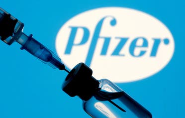A vial and syringe are seen in front of a displayed Pfizer logo in this illustration. (Reuters)