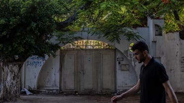A man walks past an old house in Gaza, June 24, 2021. (Thomson Reuters Foundation/Stefanie Glinski)
