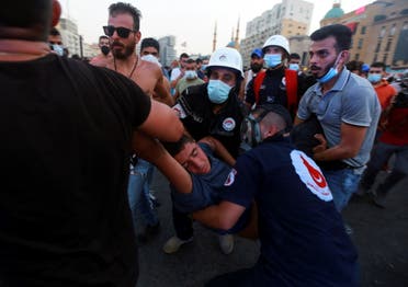 Medics evacuate a demonstrator affected by tear gas during a protest near parliament, as Lebanon marks the one-year anniversary of the explosion in Beirut, Lebanon August 4, 2021. (Reuters)
