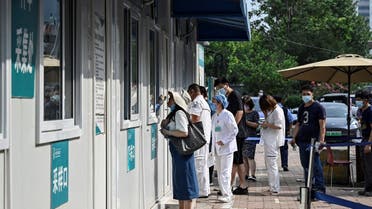 A health worker takes a swab sample from a woman to be tested for coronavirus at a hospital in Beijing on August 4, 2021. (AFP)