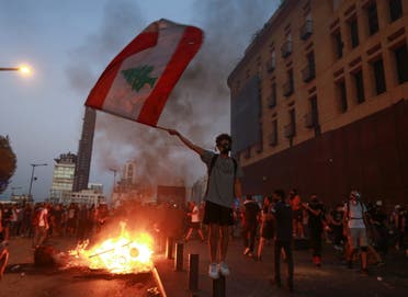Demonstrators walk near a burning fire during a protest near parliament, as Lebanon marks the one-year anniversary of the explosion in Beirut, Lebanon August 4, 2021. (Reuters)