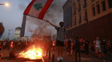 Demonstrators walk near a burning fire during a protest near parliament, as Lebanon marks the one-year anniversary of the explosion in Beirut, Lebanon August 4, 2021. REUTERS/Mohamed Azakir