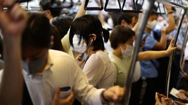People wearing protective masks amid the coronavirus disease (COVID-19) pandemic take a train on the outskirts of Tokyo, Japan, on August 5, 2021. (Reuters)
