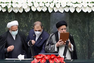 Iran's new President Ebrahim Raisi kisses the Quran during his swearing-in ceremony at the parliament in Tehran, Iran, August 5, 2021. (Reuters)