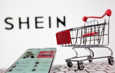 A keyboard and a shopping cart are seen in front of a displayed Shein logo in this illustration picture taken October 13, 2020. (Reuters)
