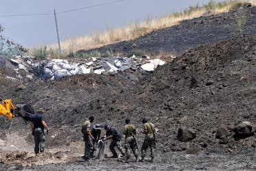 An Israeli bombs expert, accompanied by two soldiers, inspects the remains of a rocket that was fired at Israel from Lebanon, in Kiryat Shmona, Israel August 4, 2021. (Reuters)