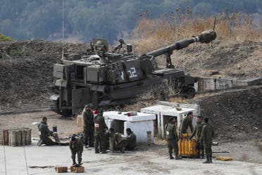 جنود إسرائيليون يقفون على الجانب الإسرائيلي من الحدود مع لبنان (رويترز)