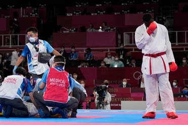 Tarek Hamedi of Saudi Arabia, right, reacts as medical personnel attend to Sajad Ganjzadeh of Iran after he was injured in their men's kumite +75kg gold medal bout for karate at the 2020 Summer Olympics, Saturday, Aug. 7, 2021, in Tokyo, Japan. (AP)