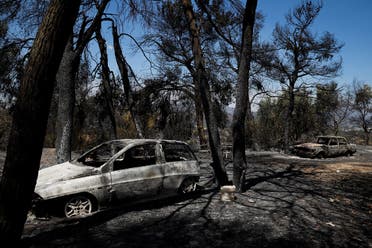 Burnt cars are seen near Agios Stefanos as a wildfire rages north of Athens, Greece, August 7, 2021. (Reuters/Costas Baltas)