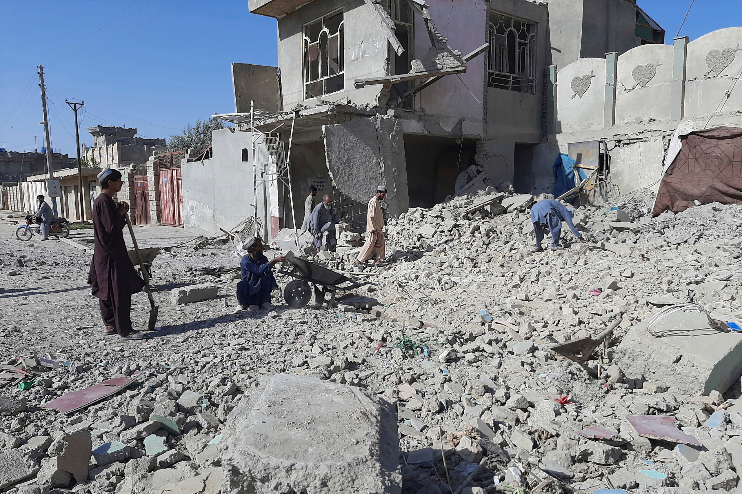 Afghans inspect a damaged building after airstrikes in Lashkar Gah city of Helmand province, southern of Kabul, Afghanistan, Sunday, Aug. 8, 2021. (AP)