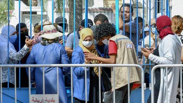 Tunisians wait for their turn to receive a COVID-19 vaccine at an inoculation center in Ariana governorate near the capital Tunis on August 8, 2021. (AFP)