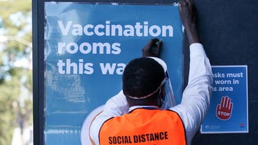 A staff member straightens a sign outside a coronavirus disease (COVID-19) vaccination clinic at the Bankstown Sports Club as the city experiences an extended lockdown, in Sydney, Australia, August 3, 2021. (Reuters)