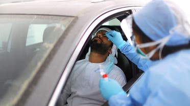 A member of medical staff wearing a protective face mask and gloves takes a swab from a man during drive-thru coronavirus disease testing (COVID-19) at a screening centre in Abu Dhabi, United Arab Emirates March 30, 2020. (File photo: Reuters)
