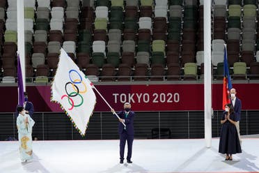  International Olympic Committee's President Thomas Bach waves the Olympic flag as Tokyo Gov. Yuriko Koike, left, and Paris mayor Anne Hidalgo, right, watch during the closing ceremony in the Olympic Stadium at the 2020 Summer Olympics, Sunday, Aug. 8, 2021, in Tokyo, Japan. (AP)
