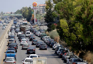 Vehicles on the right lane adjacent to the petrol station queue-up for fuel as traffic flows through the area of Naameh on the Beirut-Sidon highway, south of the Lebanese captial, on June 24, 2021 amidst severe fuel shortages. (File photo: AFP)