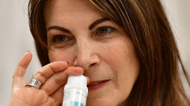 Dr. Gilly Regev, CEO and co-founder of SaNOtize, demonstrates the new ENOVID nasal spray she developed at her Vancouver, Canada office on March 26, 2021. (AFP)